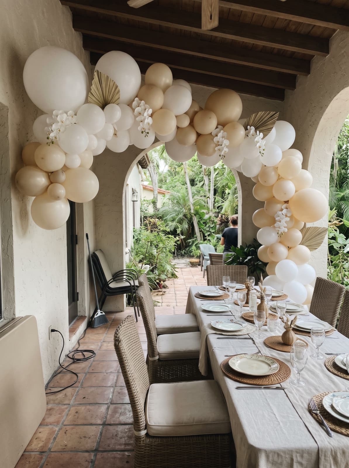 Floral balloon arch with orchids and palm fronds for a bridal shower